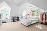 Bedroom with light colored carpet and lofted ceiling
