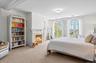 Carpeted bedroom with ornamental molding and a fireplace with flush hearth