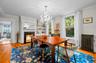 Dining space with light wood-type flooring, radiator, ornamental molding, a high end fireplace, and a chandelier