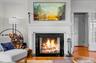 Detailed view of ornamental molding, wood finished floors, and a fireplace