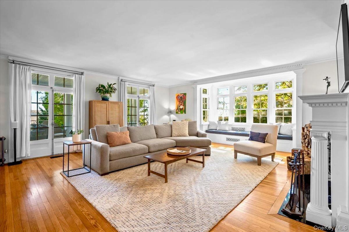 Living area with a fireplace, light wood finished floors, and ornamental molding