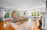 Living area with a fireplace, light wood finished floors, and ornamental molding