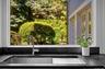 Kitchen view of a sink and dark stone countertops
