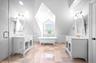Bathroom featuring a freestanding bath, two vanities, vaulted ceiling, and a shower stall