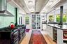 Kitchen featuring wall chimney range hood, beamed ceiling, white cabinetry, light wood-type flooring, and Aga range with two ovens