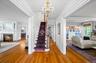 Entrance foyer featuring a chandelier, ornamental molding, hardwood / wood-style floors, stairway, and a fireplace