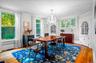 Dining area featuring beverage cooler, light wood-style flooring, crown molding, and a chandelier