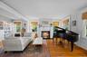 Living area with wood finished floors, healthy amount of natural light, crown molding, a fireplace with flush hearth, and radiator