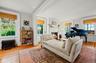 Living room featuring radiator heating unit, healthy amount of natural light, light wood-type flooring,  fireplace, and ornamental molding