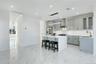 Kitchen featuring ornamental molding, a center island, glass insert cabinets, hanging light fixtures, and gray cabinets