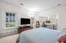 Bedroom featuring a desk, crown molding, a baseboard heating unit, carpet floors, and a baseboard radiator