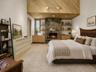 Spacious and inviting primary suite featuring soaring cathedral ceilings and a beautiful stone fireplace that adds warmth and charm. Sliding glass doo