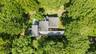 A rare aerial perspective of a truly unique estate, set on 6 private acres and surrounded by 30 + acres of protected natural beauty. From above, the h