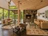 Spacious Living room with cathedral ceilings, floor to ceiling windows, sliding glass doors and a beautiful stone fireplace