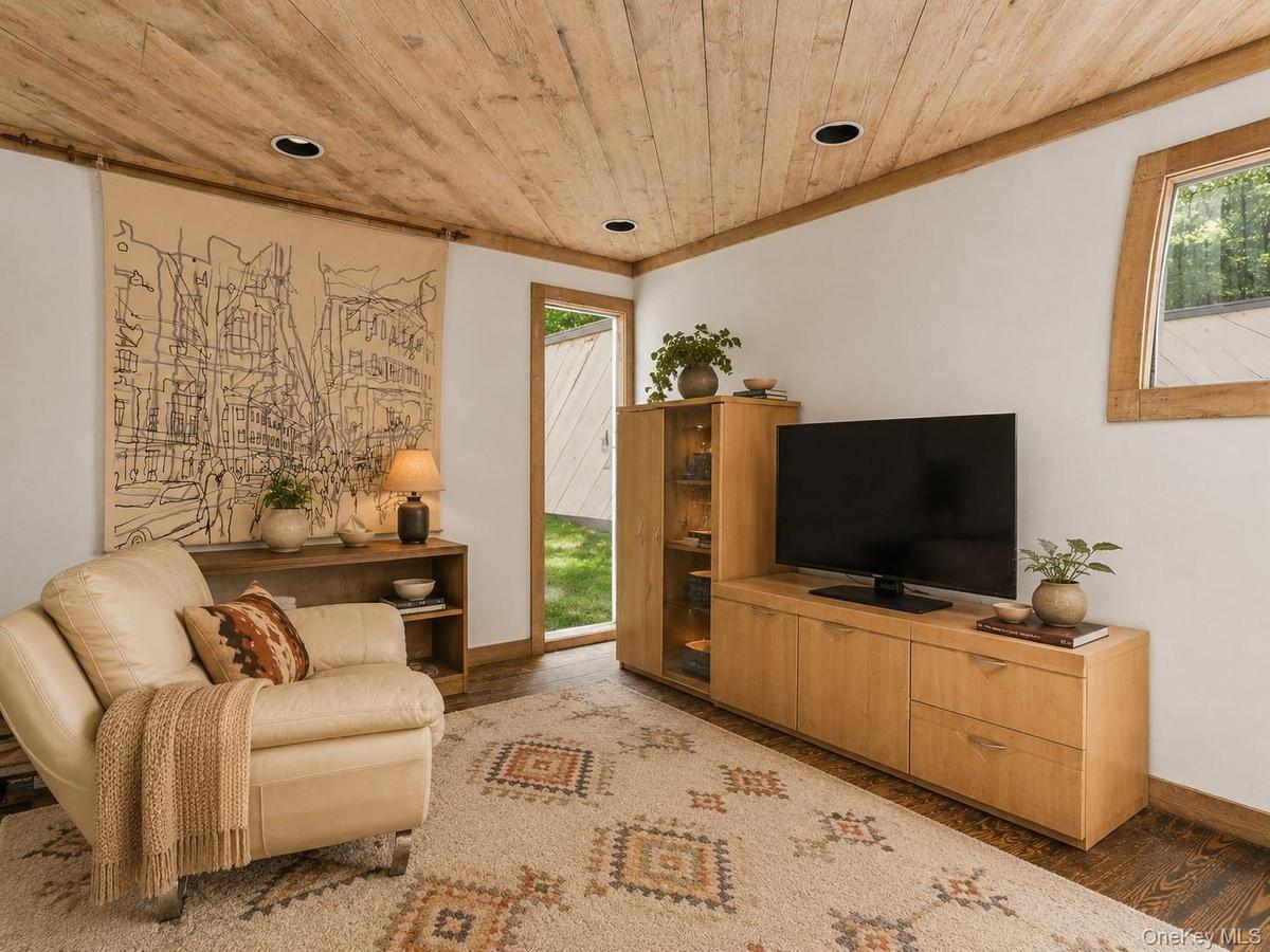 Spacious Living room with cathedral ceilings, floor to ceiling windows, sliding glass doors and a beautiful stone fireplace