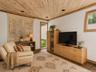 Spacious Living room with cathedral ceilings, floor to ceiling windows, sliding glass doors and a beautiful stone fireplace