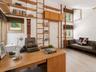 A striking loft library features soaring cathedral ceilings, unique architectural details, and floor-to-ceiling bookshelves with a classic library lad