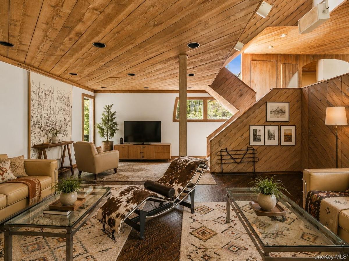 Spacious Living room with cathedral ceilings, floor to ceiling windows, sliding glass doors and a beautiful stone fireplace