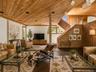 Spacious Living room with cathedral ceilings, floor to ceiling windows, sliding glass doors and a beautiful stone fireplace