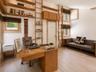 A striking loft library features soaring cathedral ceilings, unique architectural details, and floor-to-ceiling bookshelves with a classic library lad
