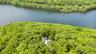 Aerial perspective of a truly unique estate, set on 6 private acres and surrounded by 30 + acres of protected natural beauty. From above, the home’s i