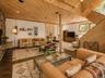 Spacious Living room with cathedral ceilings, floor to ceiling windows, sliding glass doors and a beautiful stone fireplace