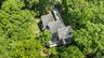 Aerial perspective of a truly unique estate, set on 6 private acres and surrounded by 30 + acres of protected natural beauty. From above, the home’s i