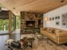 Spacious Living room with cathedral ceilings, floor to ceiling windows, sliding glass doors and a beautiful stone fireplace