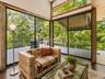 Spacious Living room with cathedral ceilings, floor to ceiling windows, sliding glass doors and a beautiful stone fireplace
