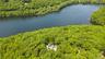 Aerial perspective of a truly unique estate, set on 6 private acres and surrounded by 30 + acres of protected natural beauty. From above, the home’s i