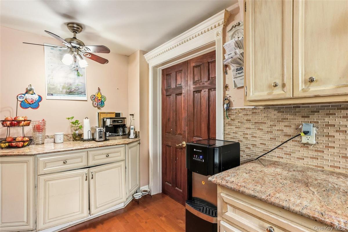 Kitchen featuring wood-finish flooring, light-toned cabinetry, and speckled countertops