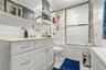 Bathroom with a white vanity featuring a light-toned countertop and chrome hardware