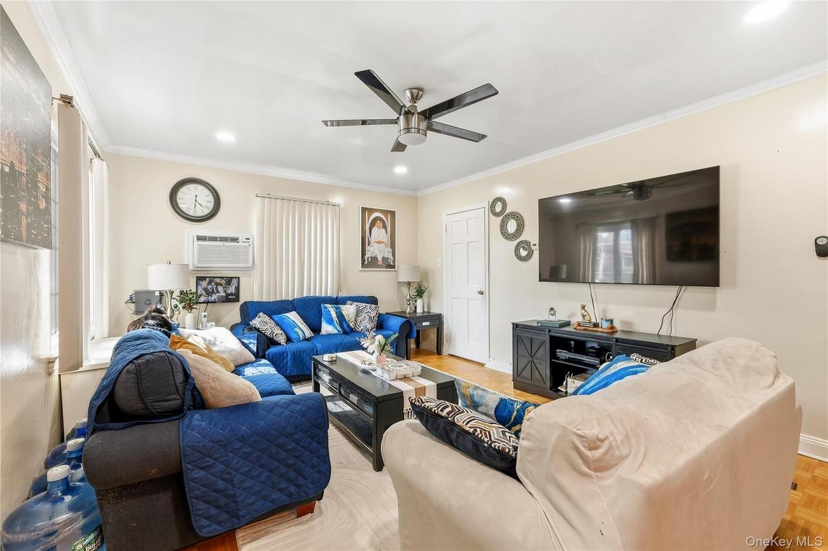 Living space featuring wood-finish flooring, crown molding, and recessed lighting