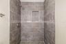 Walk-In ShowerWalk-in shower with custom tile work and built-in niche for convenience.