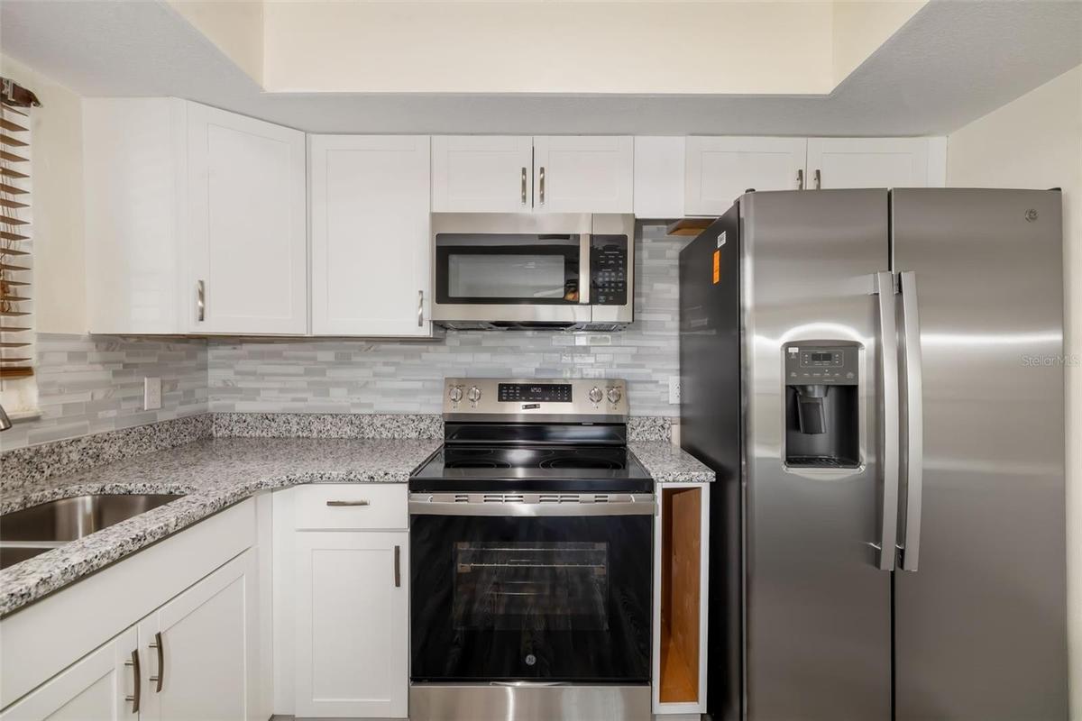 Kitchen – Close (Appliances)Updated kitchen featuring stainless steel appliances, granite countertops, and modern cabinetry.Updated kitchen featuring 