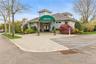 Clubhouse entrance featuring a large green awning, double entry doors, a stone facade, and shingle siding