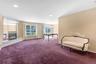 Spacious interior featuring a mirrored fireplace surround, recessed lighting, and large windows with outdoor views