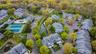 Aerial perspective showcasing a residential community with abundant mature trees and various architectural styles