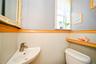 Corner-mounted sink with brushed nickel faucet, light wood trim, and a functional window.