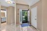 Foyer featuring ceramic tile flooring, a dark entry door with decorative glass sidelites, and a paneled white interior door