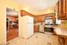 Kitchen featuring wood cabinetry, stainless steel range and dishwasher, patterned floor tiling.