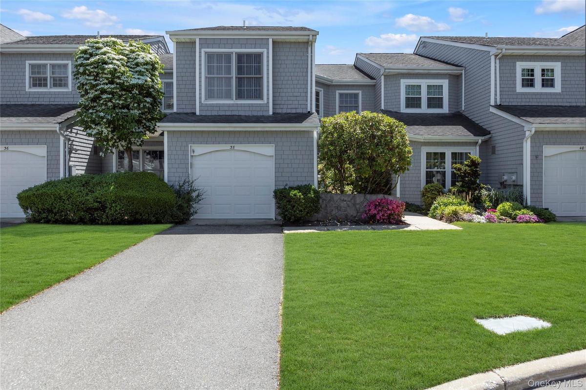 Gray shingle siding exterior with white trim windows and a white garage door