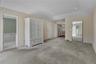 Spacious room featuring patterned wallcovering, recessed lighting, and mirrored closet doors