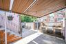 Covered patio area featuring a built-in brick barbecue station with storage, concrete flooring, and decorative perimeter fencing.
