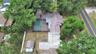 shows inground  pool with large screen enclosure, detached concrete block shed, lots of room for parking