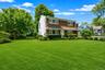 Two-story residence featuring a shingled upper facade and white siding on the lower level