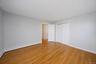 Room featuring light wood-finish flooring, light grey painted walls, and white baseboards