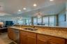 Enjoy breathtaking ocean views directly from the kitchen sink, with an open sightline through the dining and living areas to the balcony beyond.