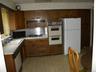 Kitchen featuring wood cabinetry, white countertops, built-in double ovens, and tile flooring