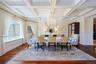 Formal dining space featuring coffered ceilings, hardwood flooring, and wainscoting